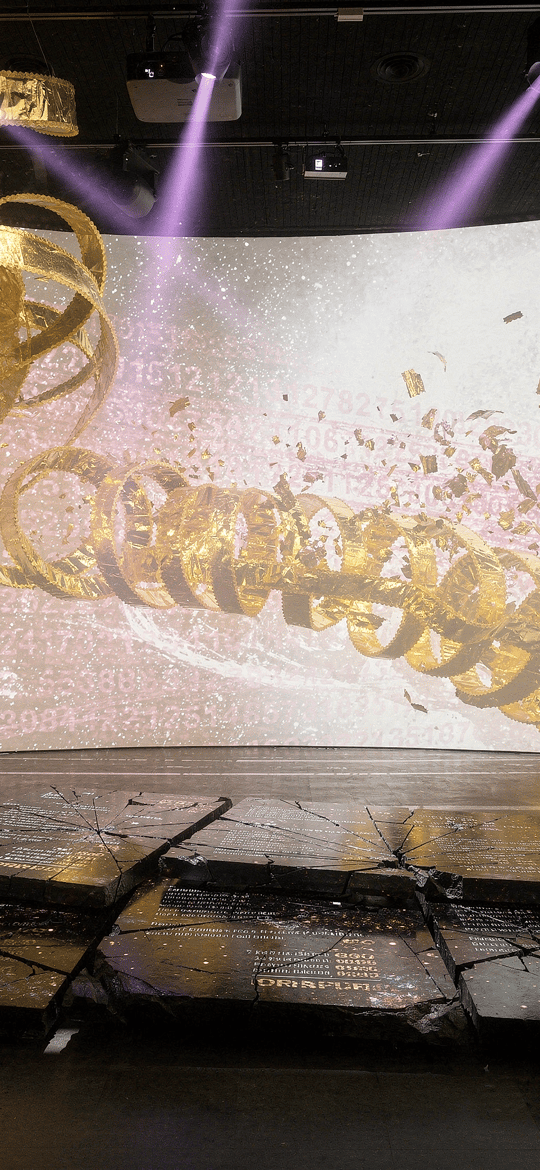 Gold Ribbons Spiraling Across a Numbered Projection Wall