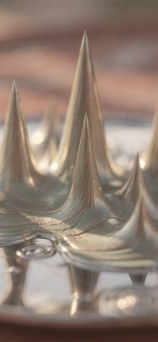 Silver Ferrofluid Spikes on Reflective Pool