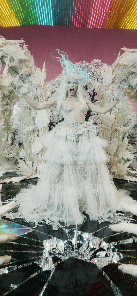 Blue-Haired Performer Amidst Feathers and Mirrors
