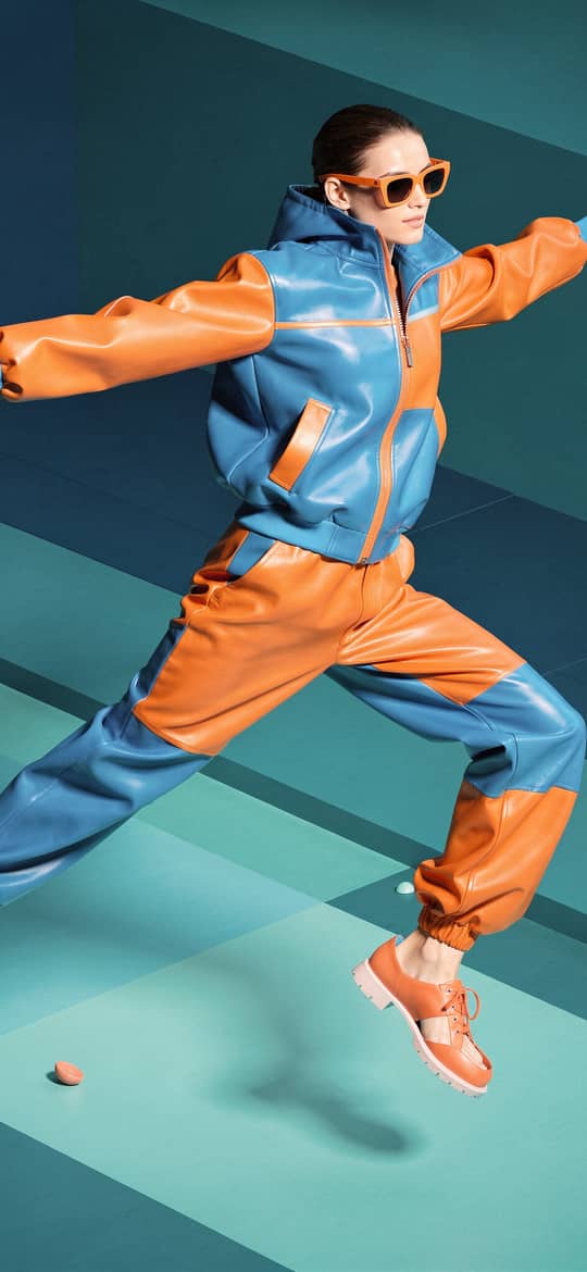 Woman Leaping in Blue Orange Tracksuit