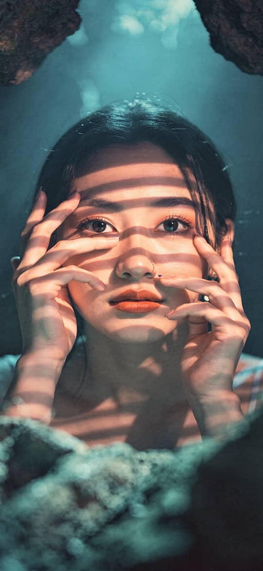 Woman in Rocky Cave with Striped Shadows
